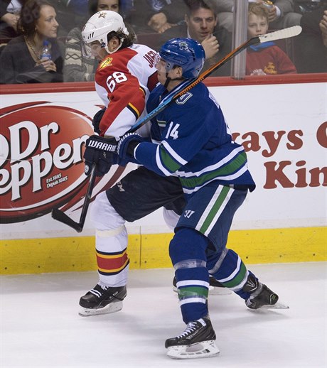 Útoník Vancouver Canucks Alex Burrows (14) v souboji s Jaromírem Jágrem (68).