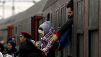 Uprchlk podv oknem vlaku dt en, po jejich pjezdu do severn Makedonie.