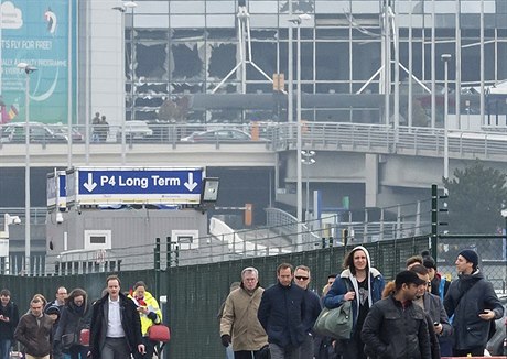 Lidé odcházejí od vysklených oken letit Zaventem v Bruselu.