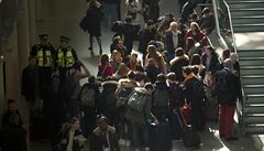 Policisté kontrolují vystupující cestující na bruselském nádraí.