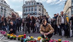 Lidé pokládají kvtiny a zapalují svíky ped budovou bruselské burzy.