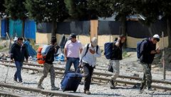 Lidé obtíení zavazadly opoutjí prostory tábora v Idomeni.