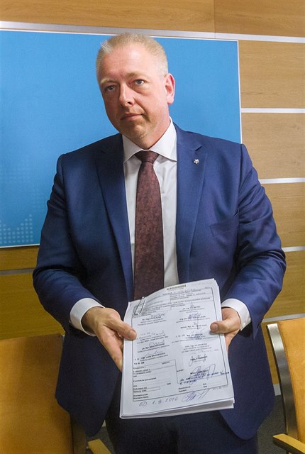 Ministr vnitra Milan Chovanec ukazuje podpisy pod policejní reformou.