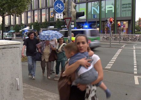 Lidé prchající z obchodního centra Olympia, krátce po vraedném útoku.