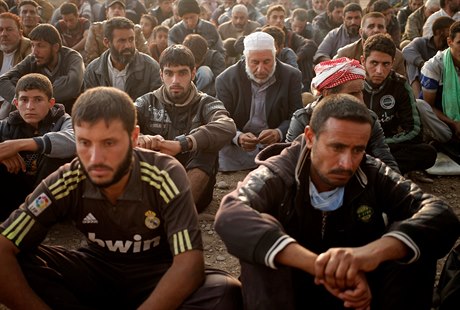 Pesunutí civilisté sedí v táboe u Mosulu.