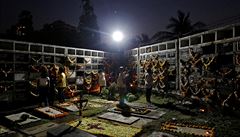 Lidé se modlí vedle hrob v indické Bombaji.
