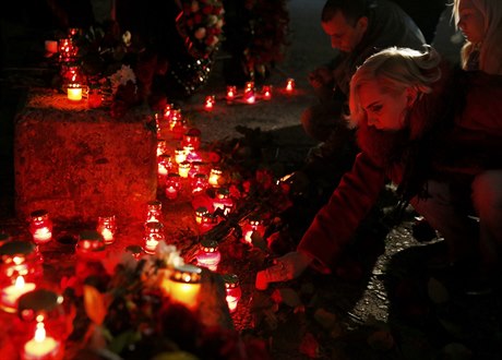 Lidé zapalují svíky za obti zíceného ruského letadla.