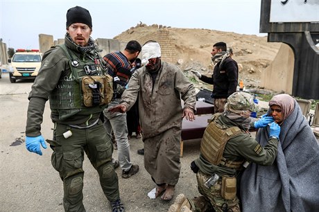 Vojáci pomáhají tce zranným civilistm.