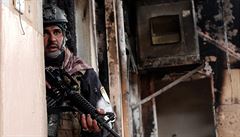 Irácký voják se kryje v jednom z dobytých dom.