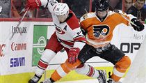 Jeff Skinner (vlevo) a Radko Gudas soupe o puk.