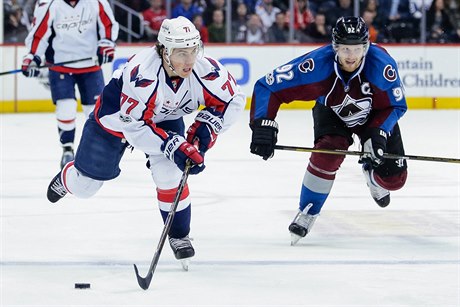 T.J. Oshie (77) z Washingtonu vede puk ped Gabrielem Landeskogem (92) z...