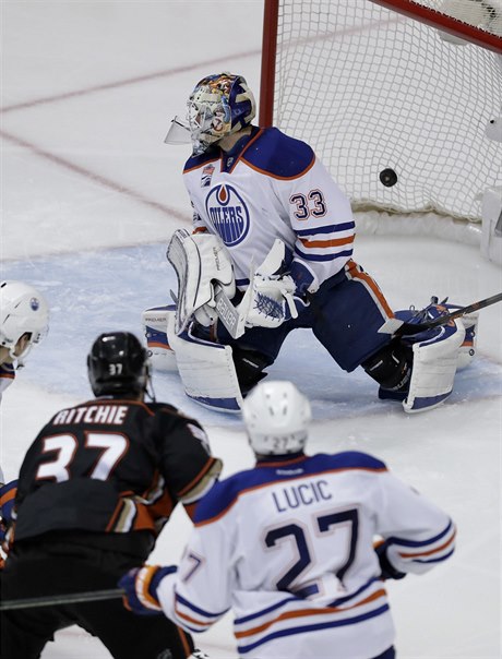 Branká Edmontonu Cam Talbot se ohlíí za pukem, který do jeho branky poslal stelec vítzné branky Nick Ritchie.