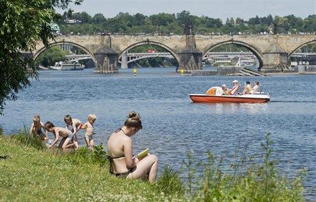 Lidé se osvují ve Vltav u Steleckého ostrova v tropickém poasí.