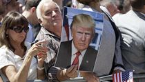 Muž „fandící“ Trumpovi čeká na jeho příjezd i s jeho velkoformátovou fotkou. | na serveru Lidovky.cz | aktuální zprávy
