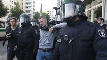 Policie odvádí jednoho ze zadržených. | na serveru Lidovky.cz | aktuální zprávy