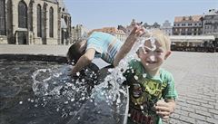 Chlapci osvující se vodou z kany v centru Plzn.