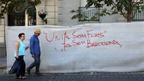 Pr prochz kolem graffiti npisu v Madridu na kterm stoj: "Spolen jsme...