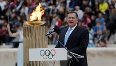 Pedseda Helénského olympijského výboru Spyros Capralos s ohnm v pozadí.