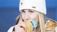 Ester Ledecká líbá svou zlatou medaili ze superobího slalomu.