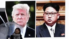 ena prochází ped obí obrazovkou s fotografiemi Kim ong-una a Donalda Trumpa.