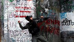 Izraelská pohraniní policie háe na druhou stranu hranice zábleskový granát.