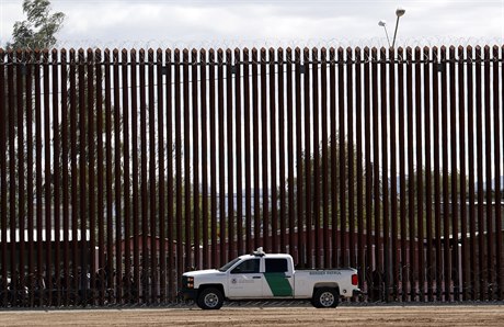 Americký celní a pohraniní vz vedle hraniní zdi mezi USA a Mexikem.