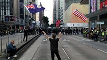 Demonstrující člověk mává vlajkami USA a vlajkou svobodného Hongkongu. | na serveru Lidovky.cz | aktuální zprávy