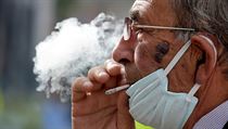 Muž v Albánii kouří cigaretu s lehce staženou rouškou, kterou má kvůli... | na serveru Lidovky.cz | aktuální zprávy