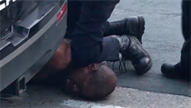 Policista klečel muži na krku.