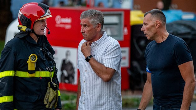 Hejtman Moravskoslezského kraje Ivo Vondrák (uprostřed) a ředitel Krajského ředitelství policie Tomáš Kužel (vpravo) hovoří s hasičem při zásahu u panelového domu v Bohumíně.
