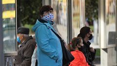 Lidé na zastávce autobusu v dob koronavirové pandemie. Ilustraní snímek