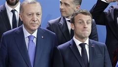 Francouzský prezident Emmanuel Macron (vpravo) stojí pi fotobrífinku vedle...