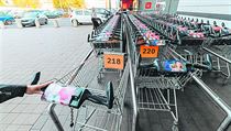 Očíslované vozíky před supermarketem.