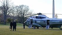 Prezident Donald Trump s manželkou kráčí k helikoptéře.