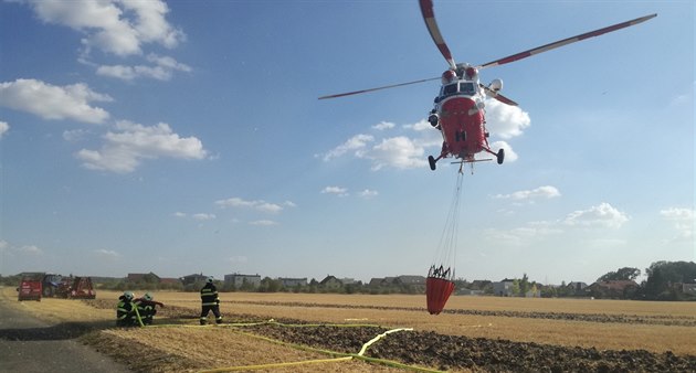 Armádní vrtulník pomáhal hasim s poárem slámy u obce Zdiby
