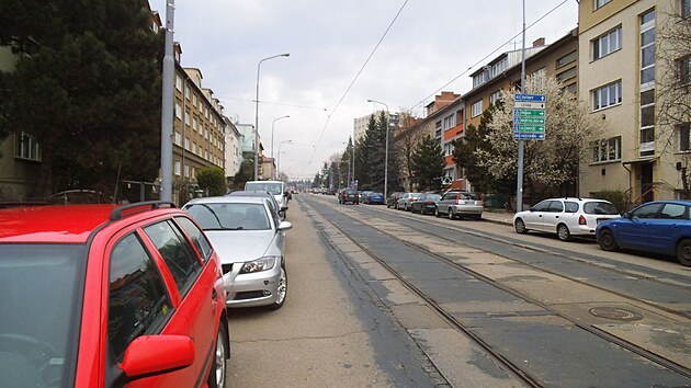 Auta vesele stoj bhem dne na ulici Merhautova ve vzdlenosti ni ne 3,5 metru od tramvaje