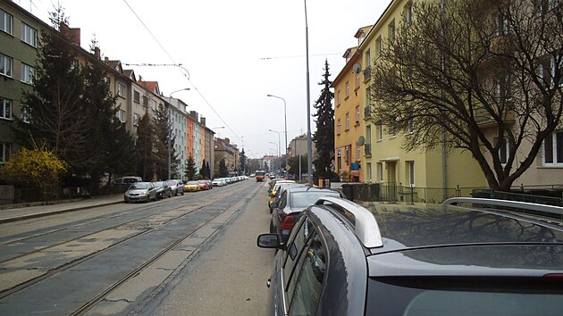 Auta vesele stoj bhem dne na ulici Merhautova ve vzdlenosti ni ne 3,5 metru od tramvaje