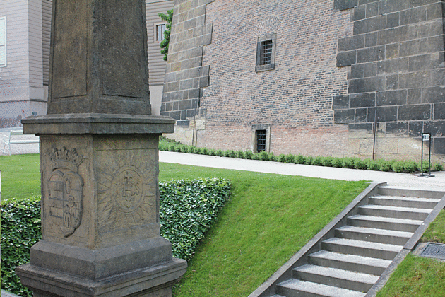 Detail Slavatova obelisku, s erbem Slavaty hrabte z Chlumu a Koumberka a symbolem IHS odkazujcm k jezuitskmu du a katolick ve (peklad: Je Spasitel Lidstva)