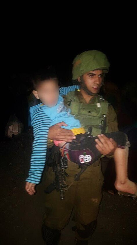 IDF soldier carries a Syrian child to get treatment in #Israel . #WorldHumanitarianDay