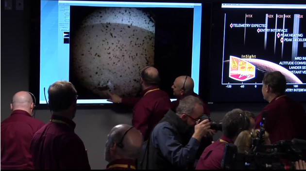 Vdci a technici v dicm stedisku hodnot pln prvn fotografii, kterou sonda InSight vyslala po pistn na Marsu 26. 11. 2018.