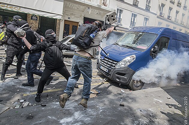 Radikln demonstranti betonovmi cihlami rozbjej pedn sklo u dodvky, kter stoj mezi nimi a policisty.Policist pod n stl granty se slznm plynem. 1.5.2019, Pa, Francie.