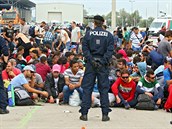 Rakoutí policisté stojí u migrant, kteí práv peli hranici u msta...