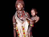 Mladá maminka z kmene Hamar ovnená barevnými perky z korálk.
