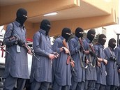 Písluníci policejních oddíl ISIS v modrých hábitech a kuklách v rukou s...