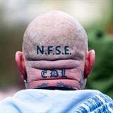 Hlavu demonstranta zdobila neonacistická tetování. EDL je zkratkou...