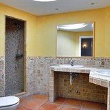 A druhá, skromnější koupelna s kamenným obložením.