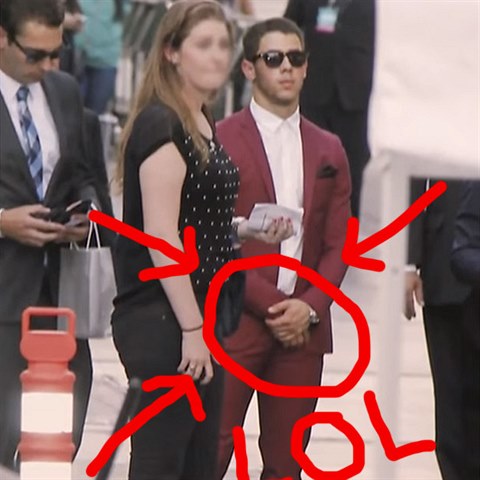 Nick Jonas m�l cel� den ruce p�ed rozkrokem.