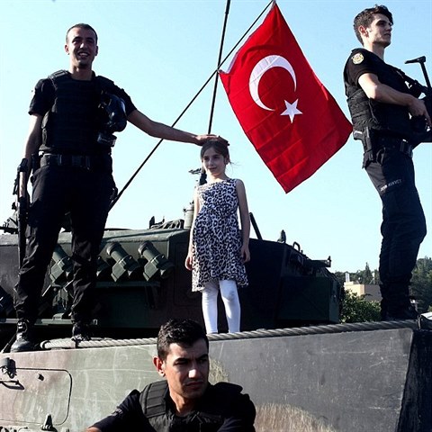 Holika s polic a tureckou vlajkou na tanku.