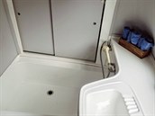 V koupeln je k dispozici umyvadlo, sprcha a praktický úloný prostor