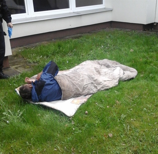 Bezdomovec si ustlal na trávníku ped kolkou.
